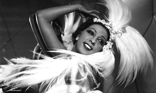 Josephine Baker performing in a dance outfit of white feathers.