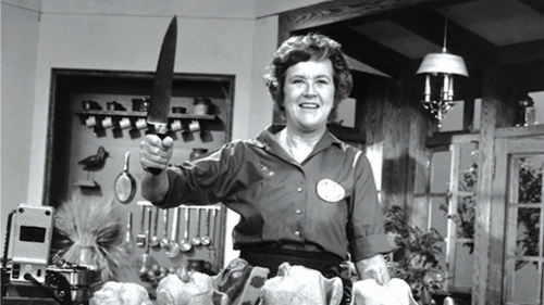 Black and white photography of Julia Child holding a kitchen knife.